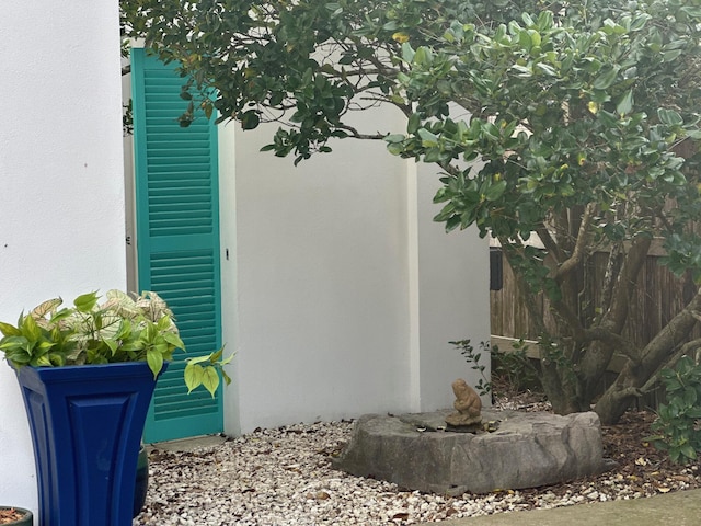 doorway to property with fence and stucco siding