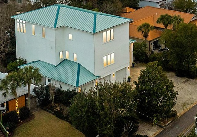 view of side of home featuring a standing seam roof, metal roof, and stucco siding