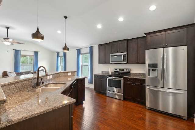 kitchen with pendant lighting, sink, dark brown cabinets, and appliances with stainless steel finishes