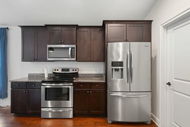 kitchen with dark brown cabinetry, appliances with stainless steel finishes, dark hardwood / wood-style flooring, and stone counters