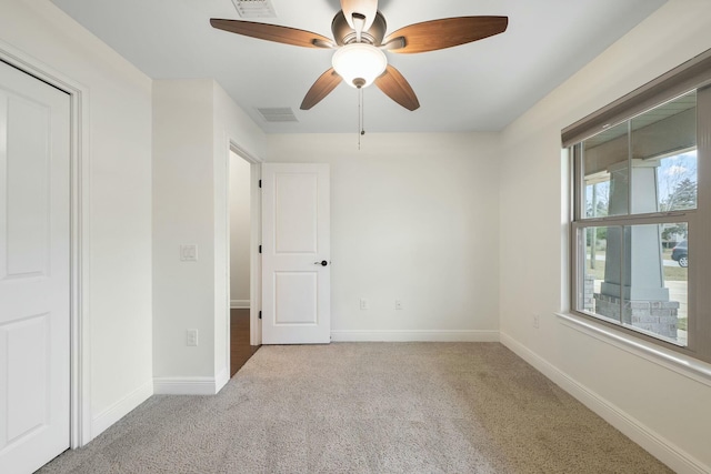 carpeted empty room featuring ceiling fan