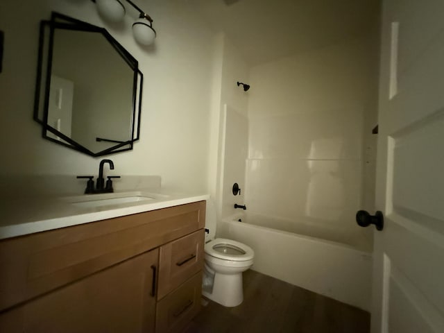 full bathroom with wood finished floors, tub / shower combination, vanity, and toilet