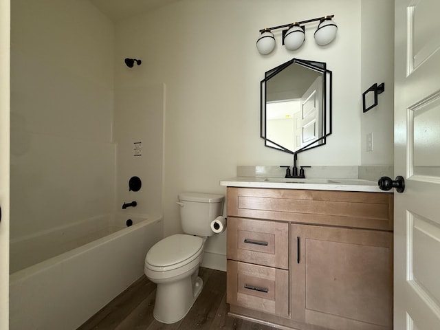 full bathroom with toilet, vanity, wood finished floors,  shower combination, and baseboards