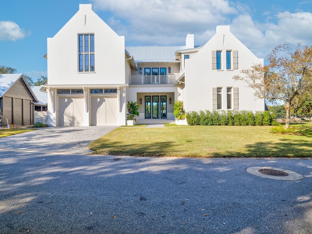 59 Arboleda Dr, Santa Rosa Beach, FL 32459 - view of front facade featuring a balcony, a garage, driveway, stucco siding, and a front yard