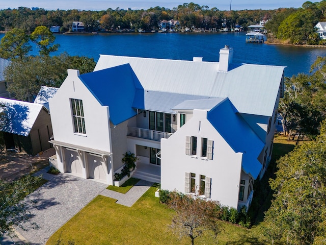 59 Arboleda Dr, Santa Rosa Beach, FL 32459 - exterior space featuring a balcony, an attached garage, a water view, a front lawn, and stucco siding