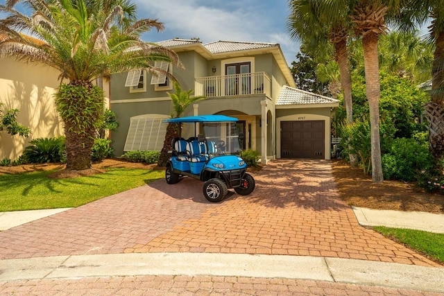 mediterranean / spanish house with a garage and a balcony