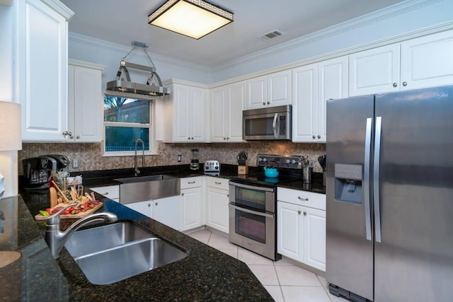 kitchen with sink, light tile patterned floors, white cabinets, and appliances with stainless steel finishes