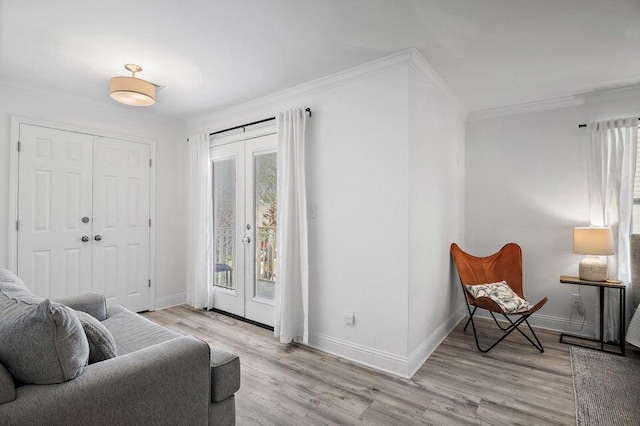 living area featuring crown molding, plenty of natural light, and light hardwood / wood-style flooring