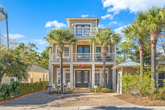 view of front of home with french doors, a porch, and a balcony