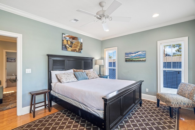 bedroom featuring multiple windows, ornamental molding, and wood finished floors