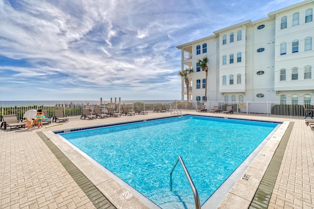 view of swimming pool featuring a patio area and fence