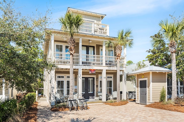 view of front facade featuring a balcony, a porch, and french doors