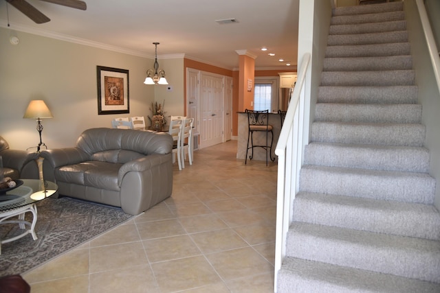 tiled living room featuring crown molding and ceiling fan with notable chandelier