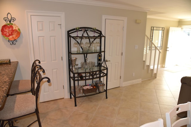 dining space with light tile patterned floors and crown molding