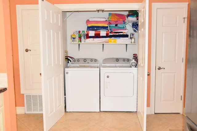 washroom featuring light tile patterned flooring and washer and dryer