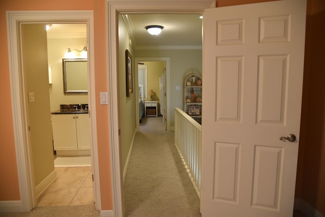 corridor with ornamental molding and light carpet