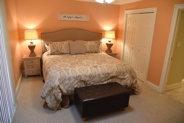 carpeted bedroom with crown molding and a closet