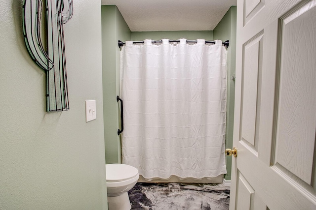 bathroom featuring toilet and a shower with shower curtain