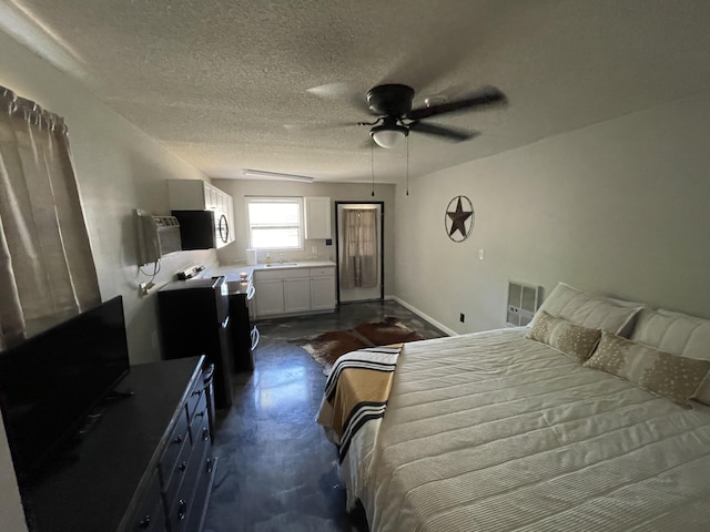 bedroom with ceiling fan, sink, and a textured ceiling