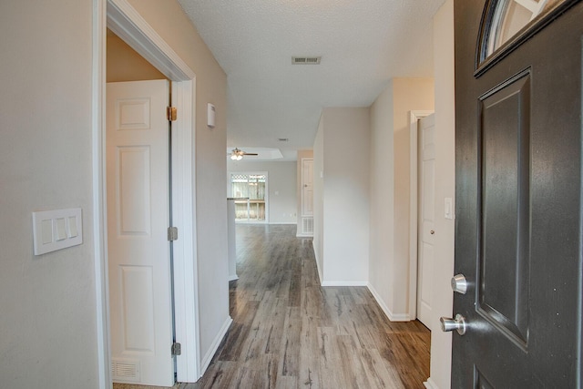 hallway featuring wood-type flooring and a textured ceiling