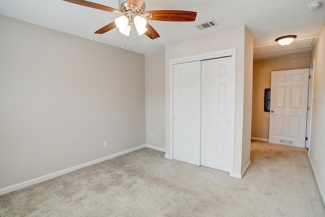 unfurnished bedroom featuring light carpet, ceiling fan, and a closet