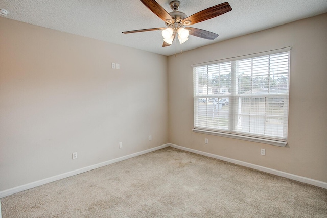 carpeted spare room with ceiling fan, plenty of natural light, and a textured ceiling