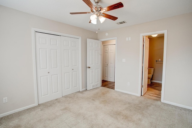 unfurnished bedroom featuring connected bathroom, light colored carpet, ceiling fan, and a closet