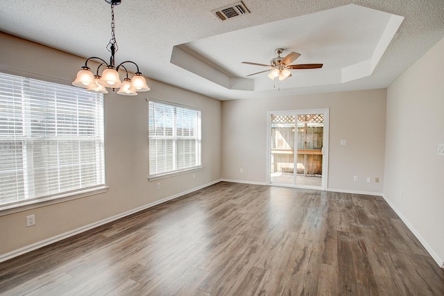 spare room with wood-type flooring, a raised ceiling, and a healthy amount of sunlight