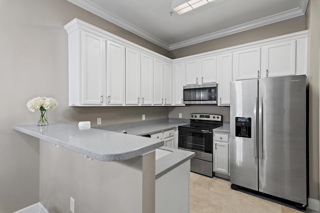 kitchen with appliances with stainless steel finishes, white cabinets, light countertops, and a peninsula