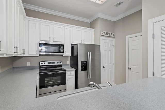 kitchen with visible vents, appliances with stainless steel finishes, ornamental molding, white cabinets, and a sink