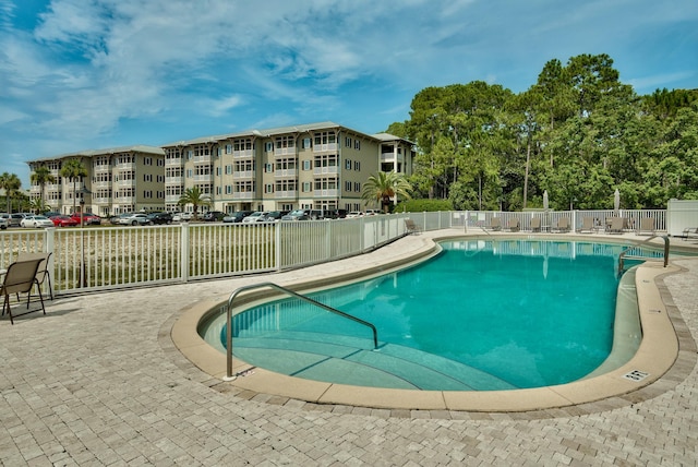 community pool featuring fence and a patio