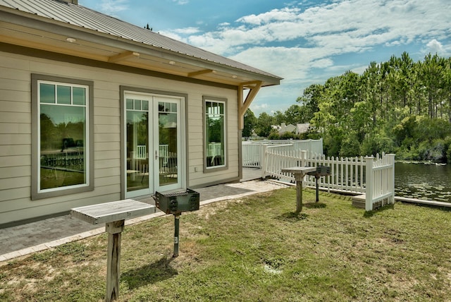 view of property exterior featuring metal roof, a yard, and french doors