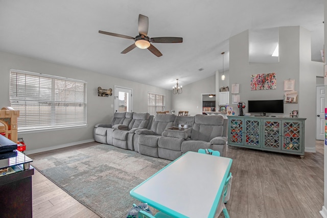 living room with lofted ceiling, ceiling fan with notable chandelier, and light hardwood / wood-style floors