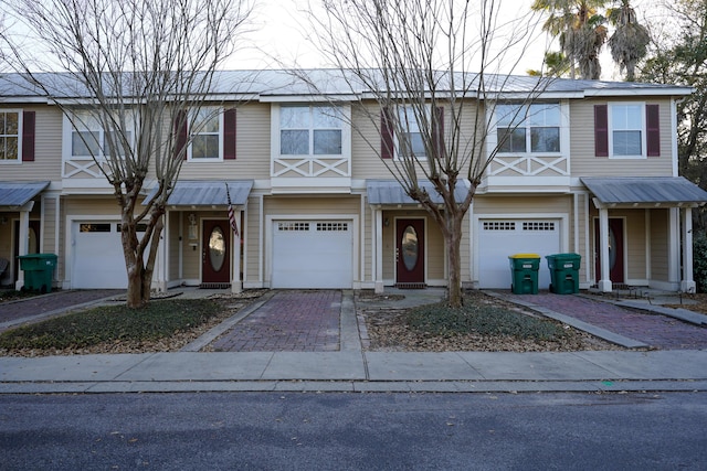 townhome / multi-family property with decorative driveway and a garage