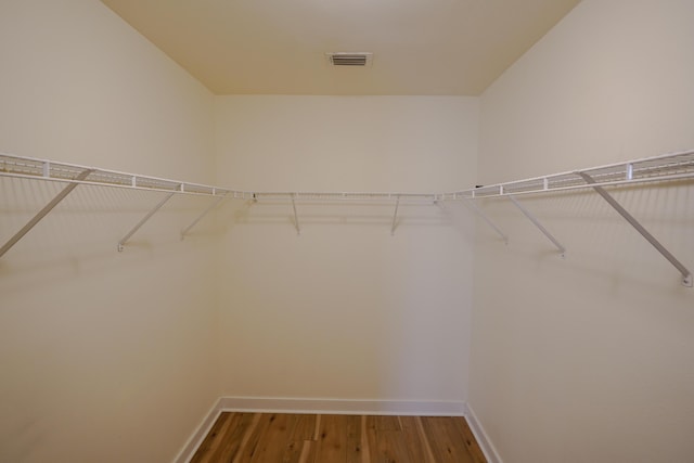 spacious closet featuring visible vents and wood finished floors