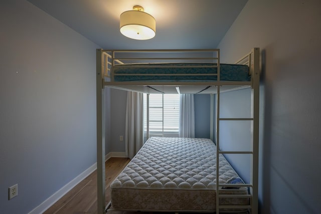 bedroom with baseboards and wood finished floors