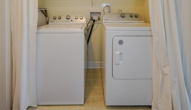 washroom with tile patterned floors, laundry area, and washer and dryer