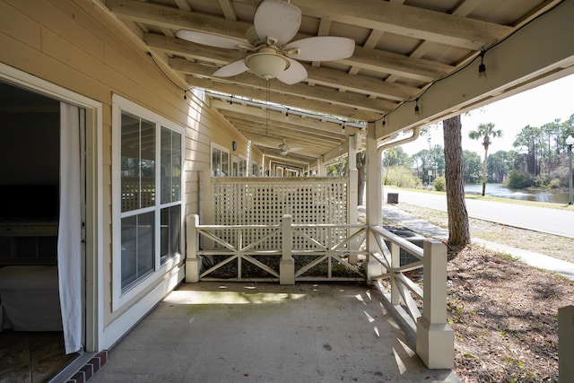 view of patio featuring a ceiling fan and a water view