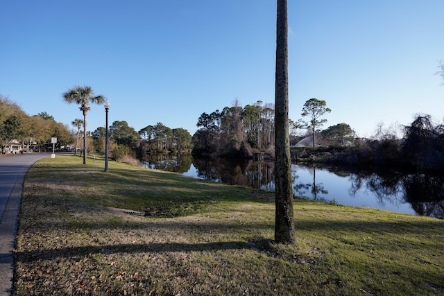 surrounding community with a lawn and a water view