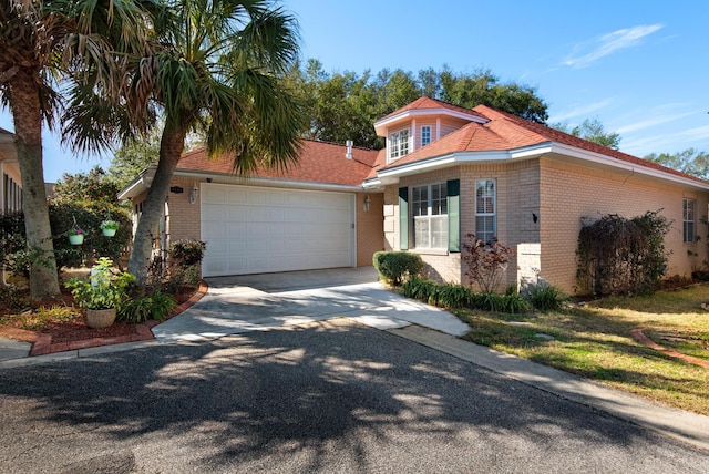 view of front of house with a garage, driveway, and brick siding