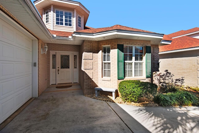 entrance to property featuring brick siding and an attached garage