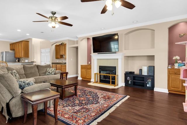 living room featuring ornamental molding, a fireplace, dark wood finished floors, and baseboards