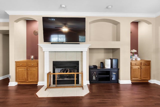 living room featuring baseboards, a fireplace, ornamental molding, and dark wood-style flooring