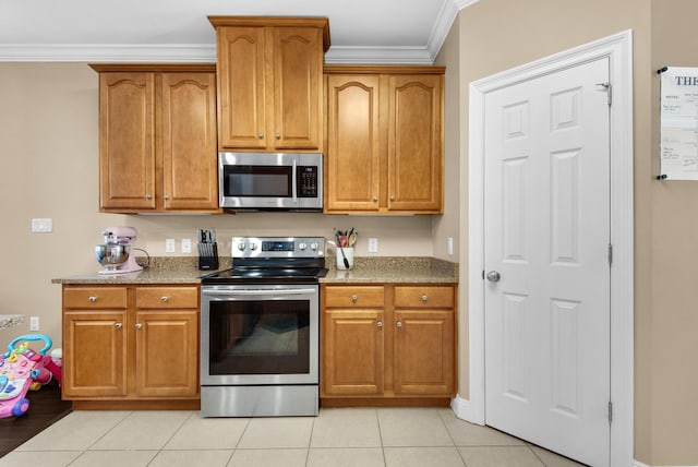 kitchen featuring appliances with stainless steel finishes, brown cabinetry, and crown molding