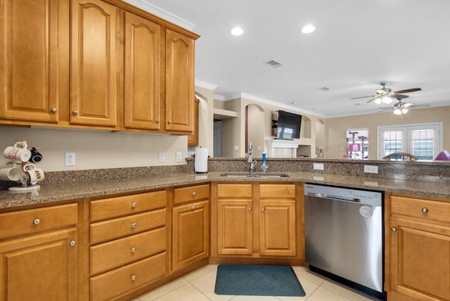 kitchen featuring dark stone counters, brown cabinets, crown molding, stainless steel dishwasher, and a sink