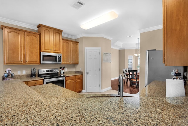 kitchen featuring visible vents, light stone counters, brown cabinets, ornamental molding, and stainless steel appliances