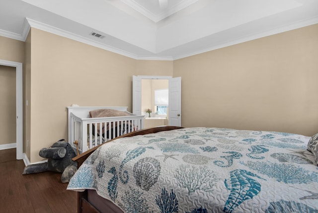 bedroom with dark wood-type flooring, visible vents, crown molding, and baseboards