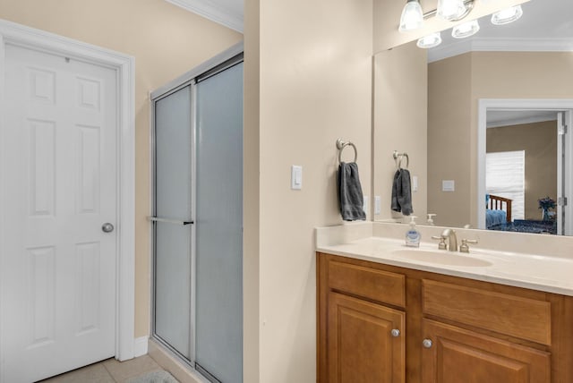 bathroom with tile patterned flooring, a shower stall, crown molding, and vanity