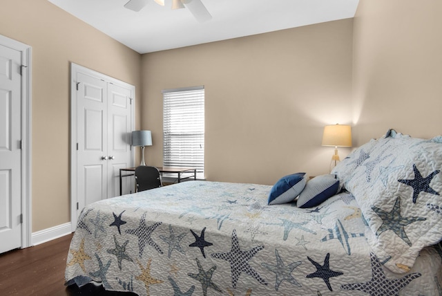 bedroom with ceiling fan, a closet, baseboards, and dark wood-type flooring