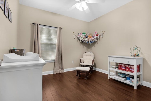 living area with ceiling fan, dark wood finished floors, and baseboards